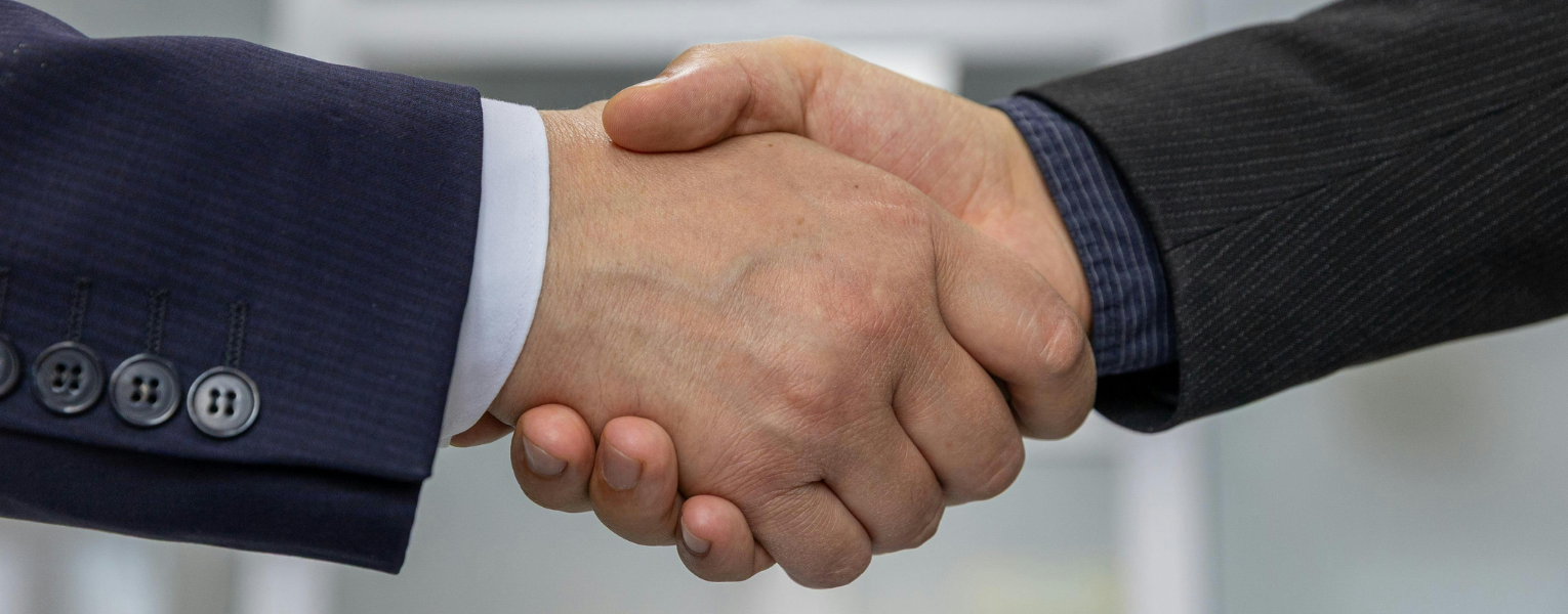 Business men shaking hands because they agree on SBA loans vs. short-term business loans